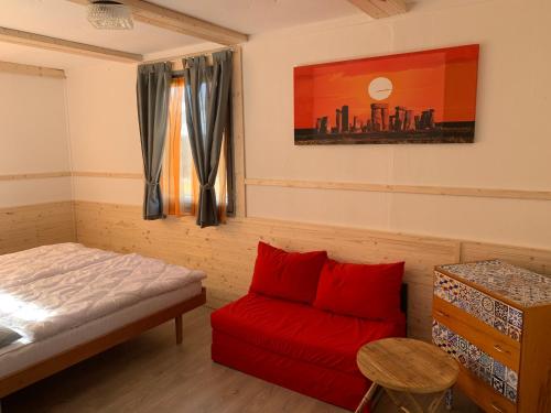霍尼普拉纳Retro chatky Hůrka Lipno的一间卧室配有一张床和一张红色的沙发
