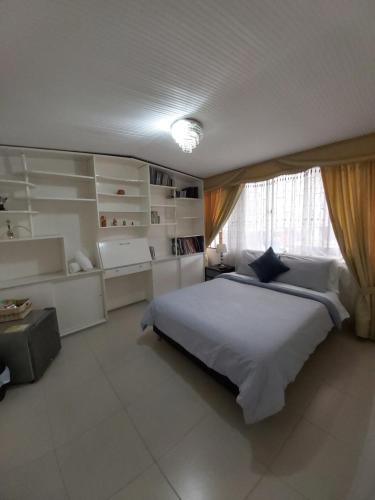 波哥大Casa Coffice的卧室设有一张白色大床和一扇窗户。
