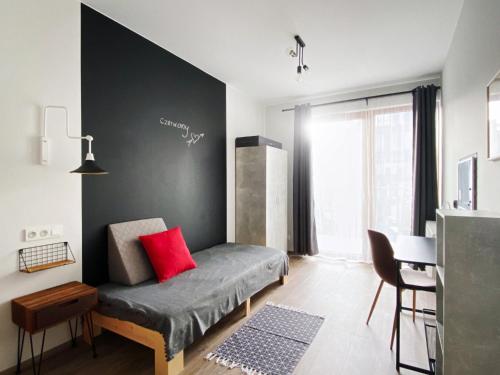 华沙3 Kolory - pokoje w mieszkaniu współdzielonym的一间卧室配有一张红色枕头的床
