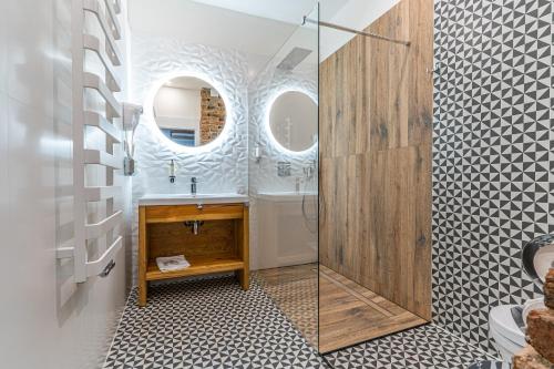 科希策Boutique Penzion Slovakia & Slovakia Residence的一间带水槽和玻璃淋浴的浴室