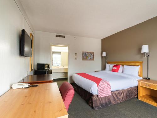 萨姆特OYO Hotel Sumter SC Downtown的酒店客房设有一张大床和一张书桌。