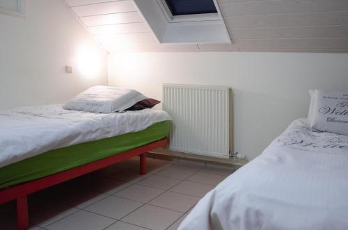 霍尔斯贝克Hageland Vakantieverblijf的一间卧室设有两张床和散热器