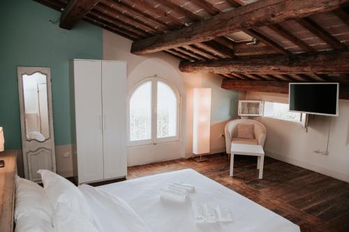 卢戈Relais Casetta 56的客厅配有白色的床和电视