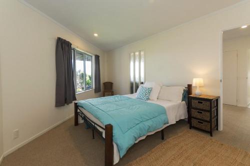 Doubtless Bay Retreat的一间卧室设有一张大床和一个窗户。