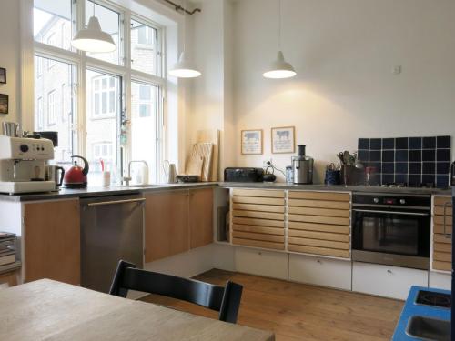 哥本哈根ApartmentInCopenhagen Apartment 1282的厨房配有不锈钢用具和桌子