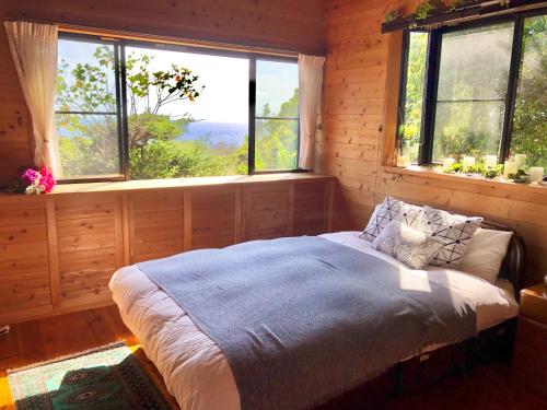 屋久岛屋久島シエスタYakushima Entire house with a wonderful view的一间设有床铺的卧室,位于带窗户的房间内