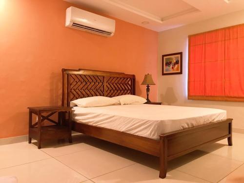 拉瓦尔品第Morgah Resort - Guest Rooms的一间卧室配有一张床和一个带风扇的窗户。