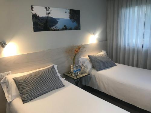 德巴凯娜拉酒店的一间卧室配有两张床和一张边桌