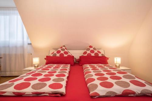 梅肯博伊伦Ferienwohnung Schürer的卧室内的两张床和红色枕头