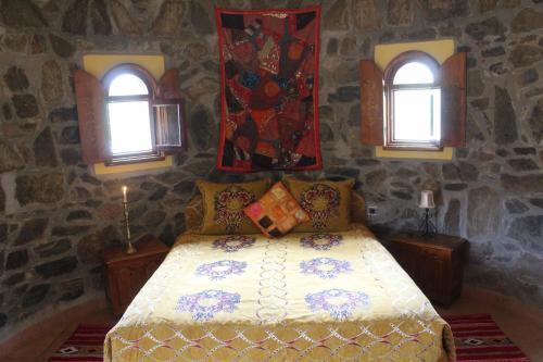 盖勒敏Complexe touristique FORT BOU-JERIF的一间卧室配有一张带两个窗户的床