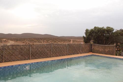 盖勒敏Complexe touristique FORT BOU-JERIF的一座带围栏和山脉的游泳池