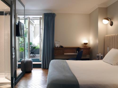 巴黎巴舒蒙特酒店的配有一张床和一张书桌的酒店客房