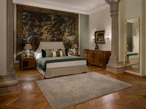萨尔茨堡蒙切斯泰恩城堡酒店的卧室配有一张床,墙上挂着一幅大画