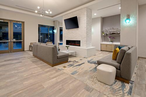 长滩Staybridge Suites - Long Beach Airport, an IHG Hotel的客厅设有两张沙发和一个壁炉