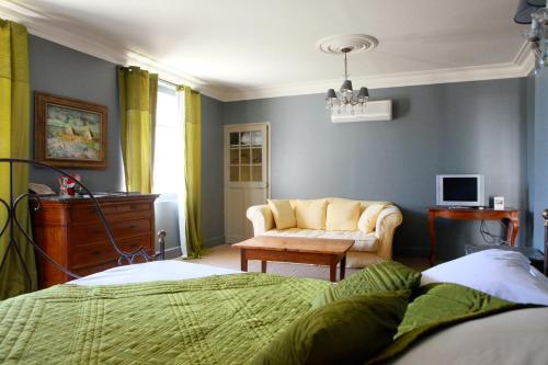 圣吉尔Mas de la Fosse的一间卧室配有一张床、一张沙发和一把椅子