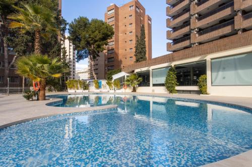 贝尼多姆Aparthotel BCL Levante Club的一座位于城市的游泳池,有高大的建筑