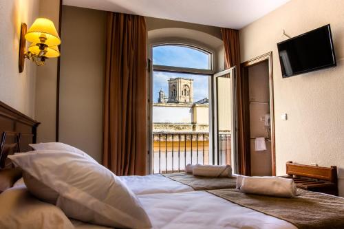 格拉纳达Hotel Reina Cristina的酒店客房设有一张大床和窗户