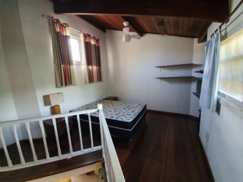 坎布里Casa em Camburi的小房间设有床和楼梯