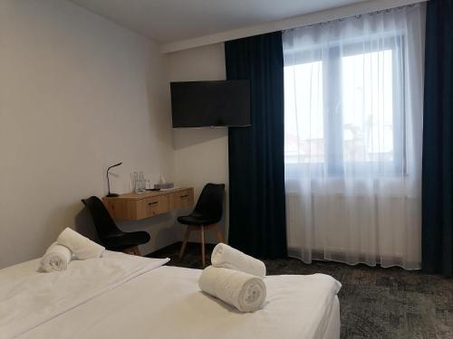 戈乌达普Pokoje Hotelowe LUPUS的酒店客房设有两张床、一张书桌和一个窗户。