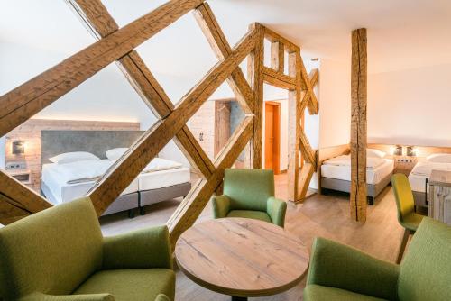特里贝格阿德勒咖啡酒店的一间卧室配有两张床和一张桌子及椅子