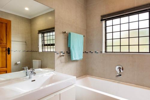 赫罗德斯湾Agape holiday house的一间带水槽、浴缸和镜子的浴室