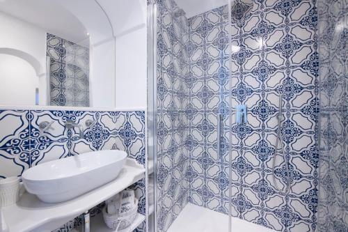 波西塔诺Maison Don Rafe'的浴室拥有蓝色和白色的瓷砖墙壁,配有淋浴。
