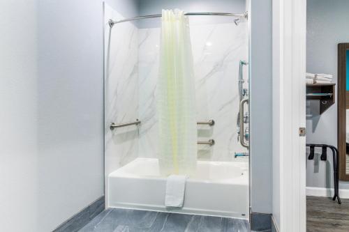 金伍德Americas Best Value Inn & Suites Kingwood IAH Airport的设有带白色浴缸的淋浴的浴室