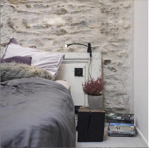 布格奈斯Plaisance Appartements & Suites - Bouguenais Apt的一间卧室设有一张床和石墙