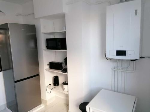 克莱蒙费朗SWEET Appartment avec Wifi et parking的带冰箱的厨房和架子上的电话