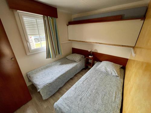 MarignyJura mobile home的小型客房 - 带2张床和窗户