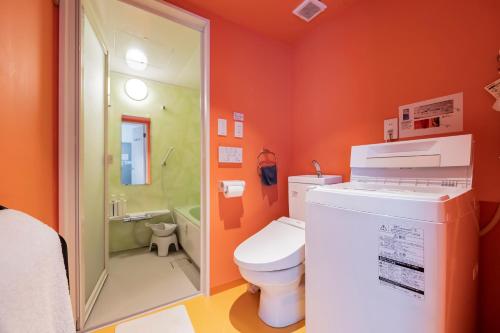 东京新宿大久保bmj公寓式酒店的橙色的浴室设有卫生间和淋浴。