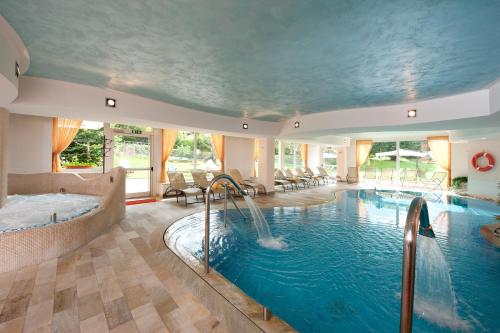 平佐洛皮妮塔中心家庭健身旅馆的一个带热水浴缸和水滑梯的大型室内游泳池