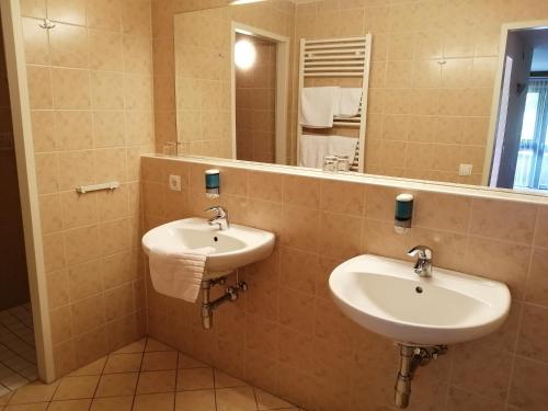 巴德小基希海姆Haus Anni的一间带两个盥洗盆和大镜子的浴室