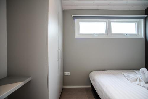 赞德沃特BUDDHA BEACH BUNGALOWS Adults Only的一间卧室设有一张床和一个窗口