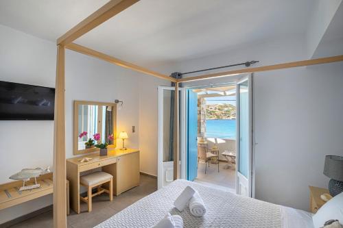 金尼昂蓝色和谐酒店的一间卧室配有一张床和一张书桌,享有海景