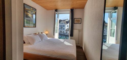 因特拉肯The Aarburg Hotel & Café的一间卧室设有一张床和一个大窗户