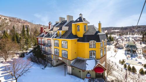 蒙特朗布朗La Tour des Voyageurs II的一座大黄色房子,地面上积雪