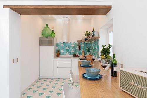 波西塔诺Petrea Lifestyle Suites的厨房配有带酒杯的木桌