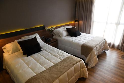 圣弗朗西斯科Hotel Soho Suites的酒店客房设有两张床和窗户。