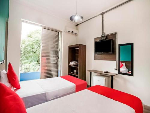 圣保罗MOVA 104 - Hotel Consulado Avenida Paulista的酒店客房设有两张床和电视。