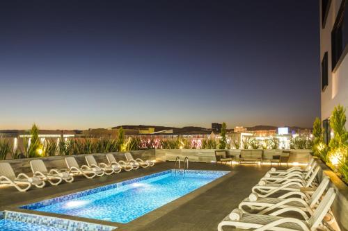 奇瓦瓦奇瓦瓦时尚购物中心菲斯塔酒店的酒店游泳池设有躺椅和游泳池