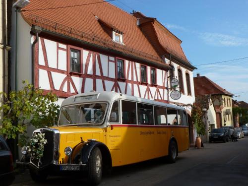 巴特迪克海姆Pfälzer Landhotel Heinrich的停在大楼前的一辆旧黄色巴士