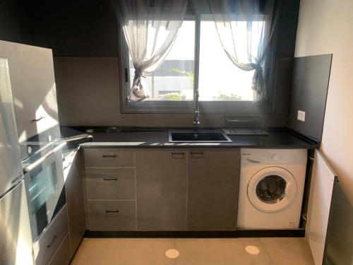 阿拉德Via Arad Apartments的厨房配有洗衣机和窗户。