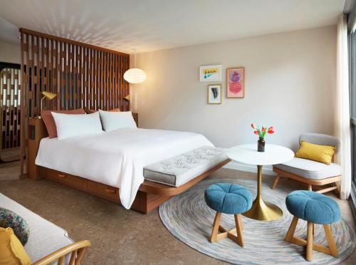 圣罗莎Flamingo Resort & Spa的卧室配有一张床和一张桌子及椅子