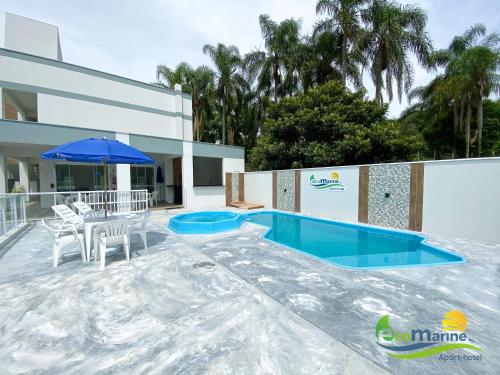 佩尼亚Ecomarine Apart-hotel 800 m Beto Carrero的一个带桌椅和遮阳伞的游泳池