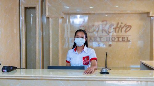 圣克鲁斯Buen Retiro Apart Hotel的一名戴面具的女士在饭店的柜台