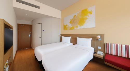 浦那ibis Pune Hinjewadi - An Accor Brand的一间酒店客房,设有两张床和电视