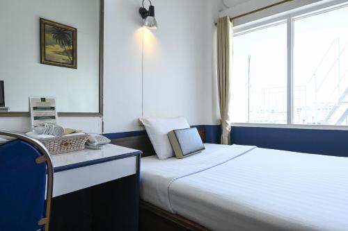曼谷The Krungkasem Srikrung Hotel的一间卧室设有一张大床和一个窗户。