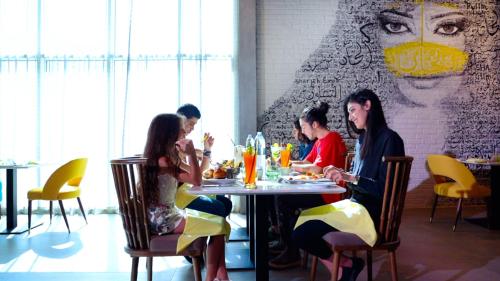 沙迦Pullman Sharjah的一群坐在餐厅桌子上的人