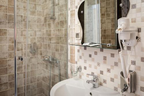 梁赞普里奥斯卡娅酒店的浴室配有盥洗盆和带镜子的淋浴
